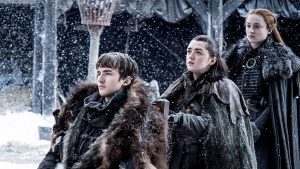 Bran en fauteuil avec ses soeurs Arya et Sansa à Winterfell, sous la neige, GoT